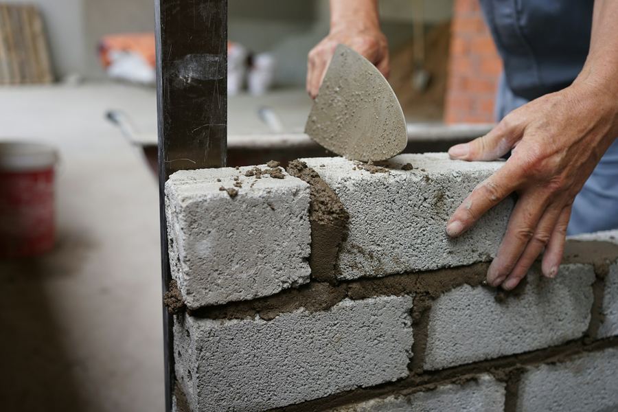 Application du mortier sur une rangée de briques